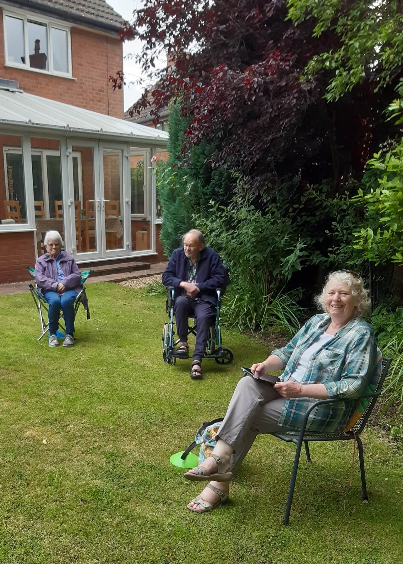 A socially distanced carers' choir sitting in a garden.